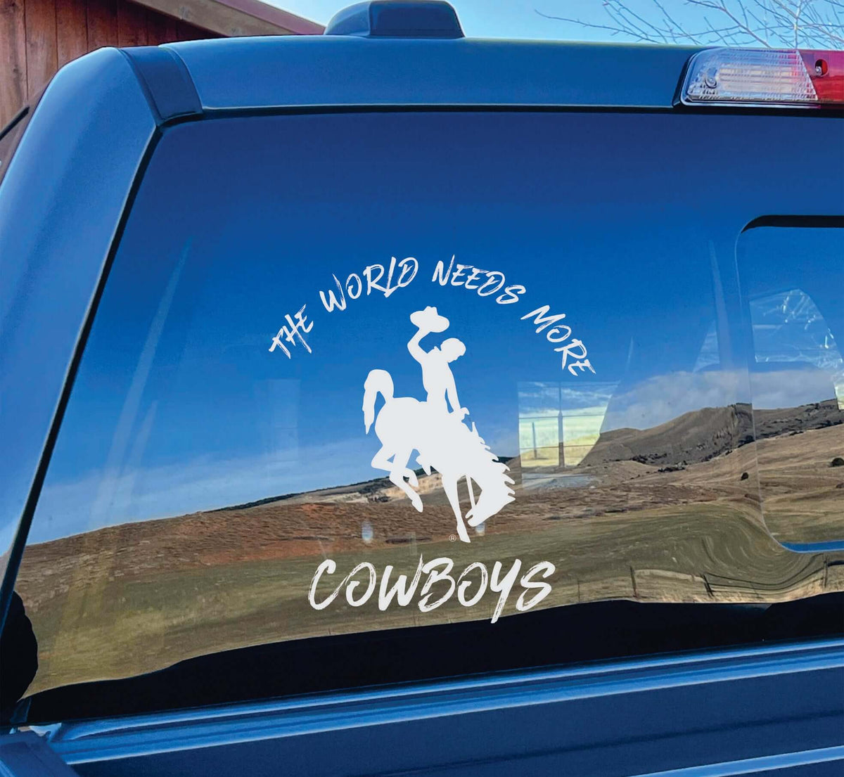 Photo of white vinyl decal &quot;World Needs More Cowboys&quot; on car window