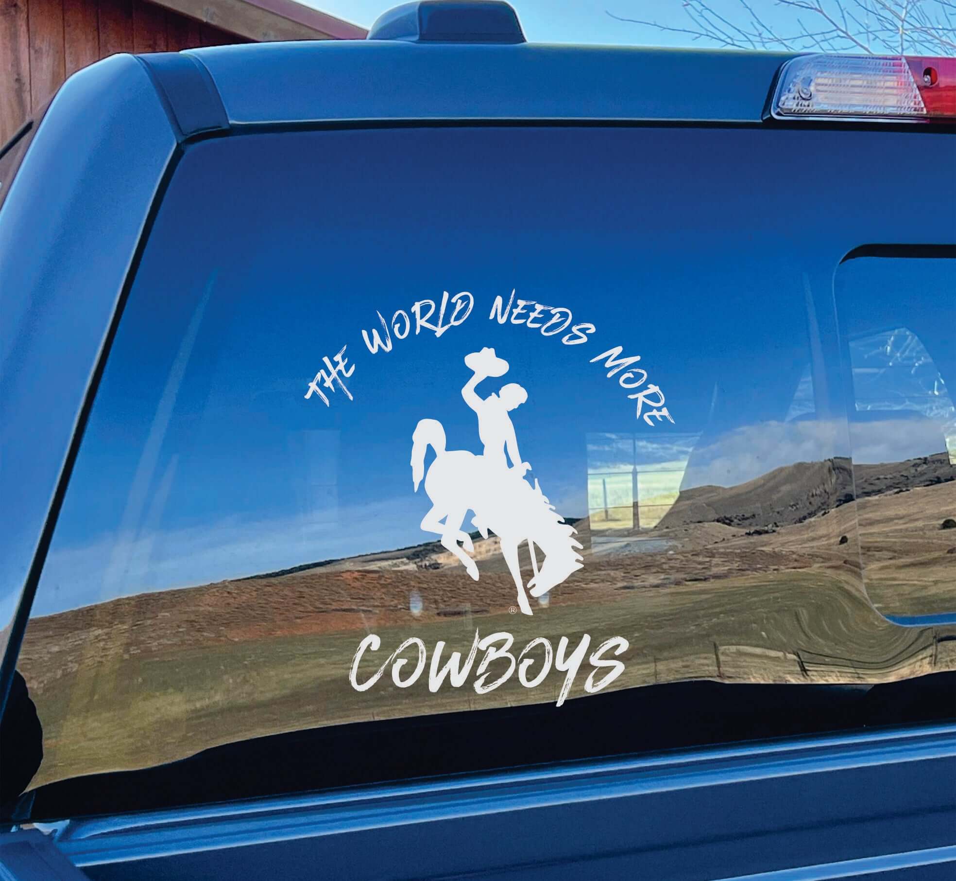 Photo of white vinyl decal "World Needs More Cowboys" on car window