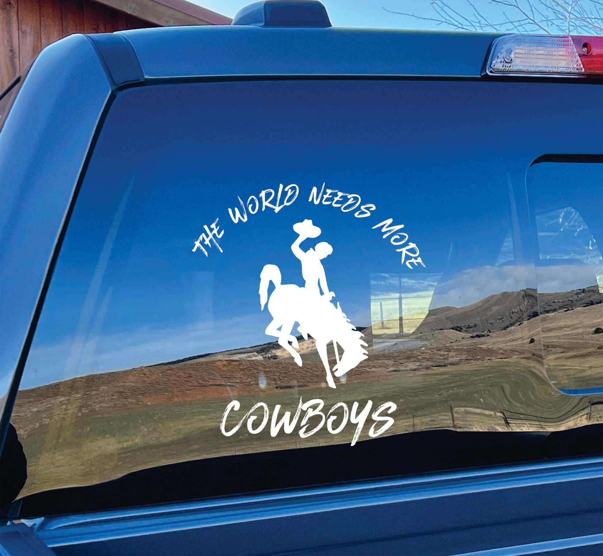 Alternate view of white vinyl decal "World Needs More Cowboys" on car window